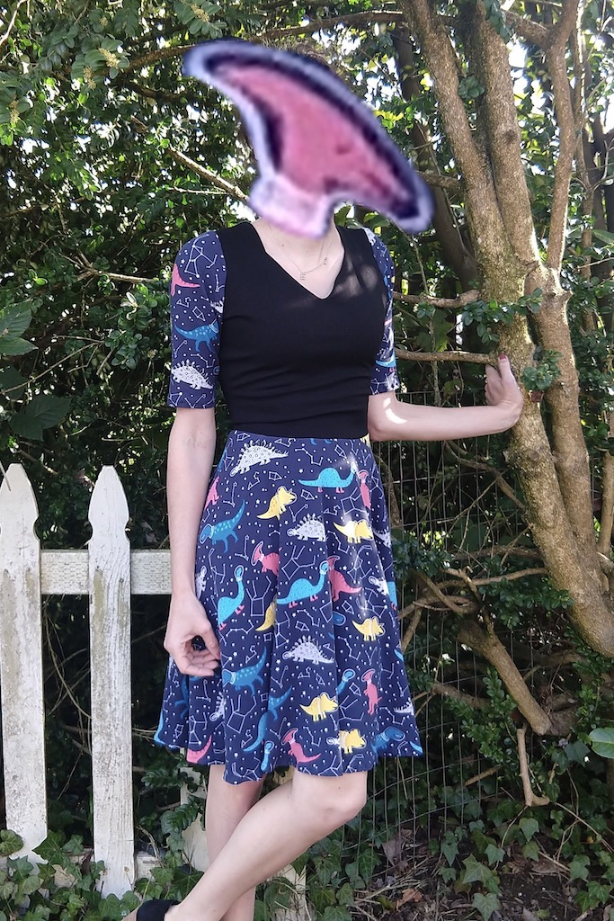 A dress made out of fabric covered in pictures of dinosaurs in space