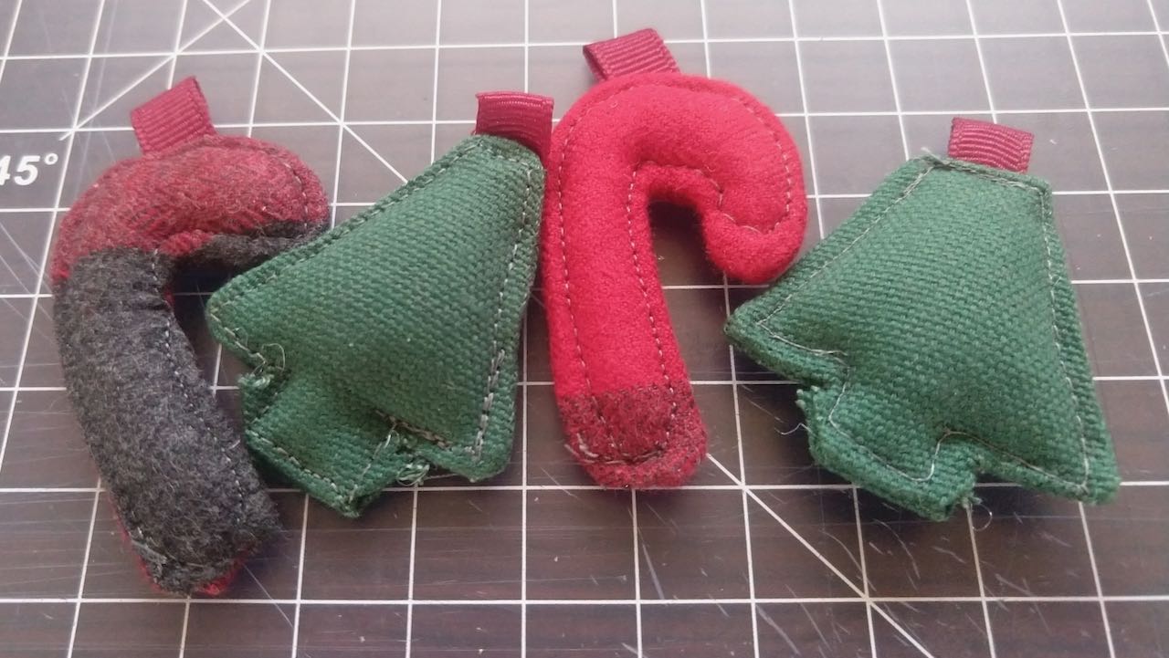 two small flannel candy canes and two green canvas christmas trees